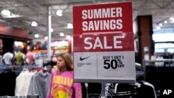 FILE: A "sale" sign is displayed for clothes at a retail store in Vernon Hills, Ill., on Mon. June 12, 2023. 