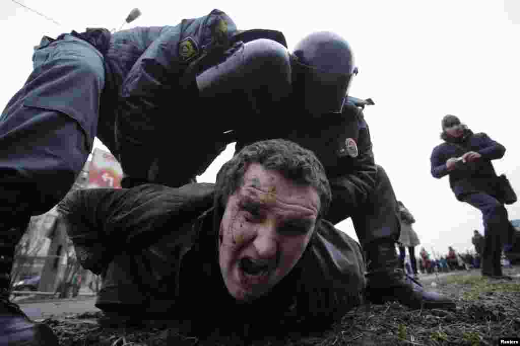 Interior Ministry members detain a man during a protest rally held by opposition activists and members of the Other Russia movement in St. Petersburg. Demonstrators demanded an abolishment of the results of the privatization of the state property and primary resources which took place in the 1990s and protested against plans by authorities for further privatization, according to organizers.