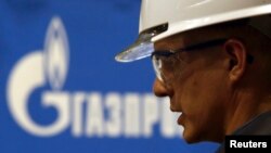 An employee works on pipes made for the South Stream pipeline near a Gazprom logo at the OMK metal works in Vyksa in the Nizhny Novgorod region, April 15, 2014. 