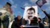 FILE - A demonstrator holds a picture of Kurdistan Workers Party leader Abdullah Ocalan during a rally in Diyarbakir, Turkey, Feb. 27, 2025.