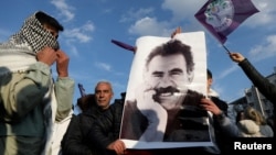 FILE - A demonstrator holds a picture of Kurdistan Workers Party leader Abdullah Ocalan during a rally in Diyarbakir, Turkey, Feb. 27, 2025.