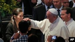 El Papa toca la cabeza de una niña a su llegada al Mall of Asia en Manila, este viernes, 16 de enero, de 2015.