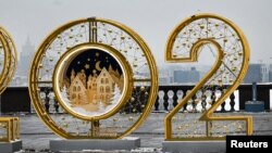 A man walks past large numbers for the upcoming year 2021, as part of Christmas and New Year decorations at Vorobyovy Hills observation point in Moscow on December 14, 2020. (Photo by Alexander NEMENOV / AFP)