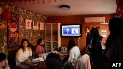 A group of Chinese students who study at U.S. universities watch online live coverage of the U.S. presidential election at an apartment in Beijing on Nov. 4, 2020.