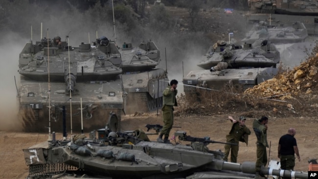 Israeli army tanks maneuver in a staging area in northern Israel near the Israel-Lebanon border, Oct. 1, 2024.