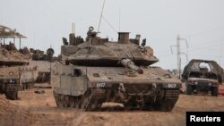 Sebuah tank dan kendaraan militer Israel terlihat di dekat perbatasan Israel dengan Jalur Gaza, di Israel selatan, 22 Oktober 2023. (Foto: REUTERS/Violeta Santos Moura)