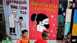 Anak-anak bermain di dekat mural untuk meningkatkan kesadaran pandemi corona dan pesan untuk menghormati orang yang lebih tua di Jakarta, 4 Agustus 2020. (Foto: dok). Presiden Jokowi menargetkan angka stunting bisa turun ke level 14 persen pada tahun 2024.