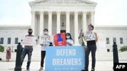 FILE - Deferred Action for Childhood Arrivals (DACA) demonstrators stand outside the U.S. Supreme Court in Washington, June 15, 2020. 