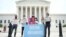 FILE - Deferred Action for Childhood Arrivals (DACA) demonstrators stand outside the U.S. Supreme Court in Washington, June 15, 2020. 