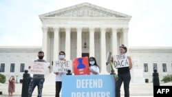 FILE - Deferred Action for Childhood Arrivals (DACA) demonstrators stand outside the U.S. Supreme Court in Washington, June 15, 2020. 