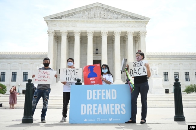 FILE - Deferred Action for Childhood Arrivals (DACA) demonstrators stand outside the U.S. Supreme Court in Washington, June 15, 2020.