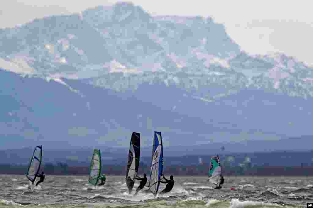 گروهی از موج‌سواران، با استفاده از وزش باد شدید در دریاچه آمرسی در جنوب‌غربی مونیخ به موج‌سواری مشغول هستند.