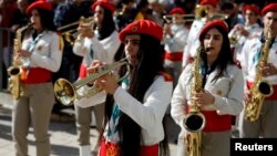 Para anggota marching band Palestina ikut memeriahkan parade untuk merayakan Natal di Lapangan Manger, di luar gereja Nativity, Bethlehem, Tepi Barat, Senin (24/12). 