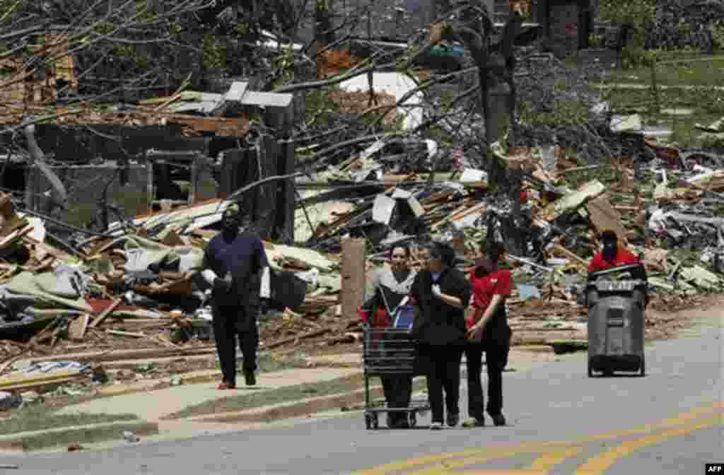 People walk near University Boulevard with their belongings Thursday April 28, 2011, after a tornado struck Tuscaloosa, Ala. the day before. Massive tornadoes tore a town-flattening streak across the South, killing at least 269 people in six states and fo