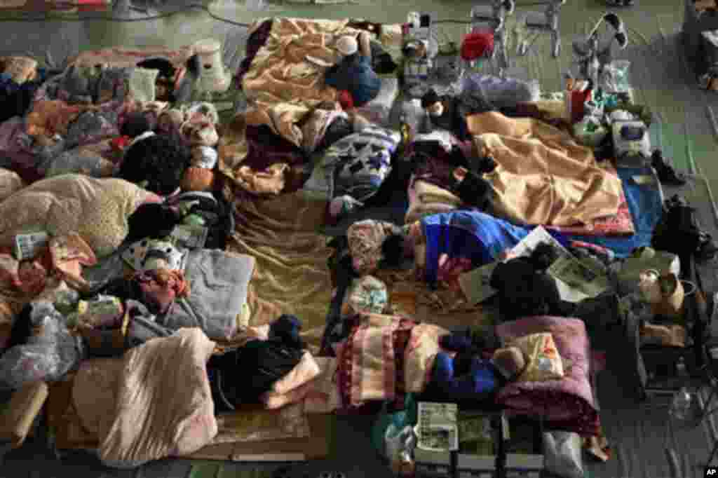 . Local people keep warm under covers in a school gymnasium being used as a center for people to stay at whose homes were damaged by the tsunami in Ofunato. (AP Image)
