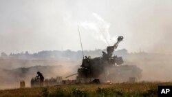 Sebuah unit artileri Israel menembak ke sasaran di Jalur Gaza, di perbatasan Israel-Gaza, Minggu, 16 Mei 2021. (Foto AP / Heidi Levine)