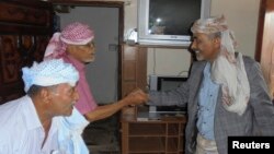 Yemen's Defence Minister General Mahmoud al-Subaihi, right, shakes hands with visitors in his home in Yemen's southern province of Lahej, where he fled from the capital, Sana'a, March 8, 2015. 