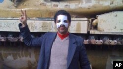 One of the organizers of the protests in Egypt, Ahmed Saleh stands in front of a tank with a bandaged broken nose he sustained during the uprising