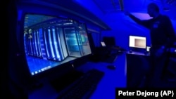 FILE: This Friday Jan. 11, 2013 file photo of a member of the Cybercrime Center as he turns on the light in a lab during a media tour at the occasion of the official opening of the Cybercrime Center at Europol headquarters in The Hague, Netherlands.