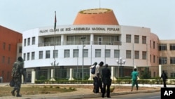 A picture taken on March 19, 2012 shows residents walking by the Parliament in Bissau. 