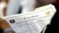 In this Thursday, June 21, 2018 photo, a job applicant looks at job listings for the Riverside Hotel at a job fair hosted by Job News South Florida, in Sunrise, Fla. 