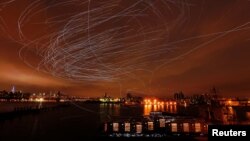 LED lights attached to pigeons leave light trails in the sky while they fly as part of the "Fly By Night" art installation by Duke Riley above the Brooklyn borough of New York, May 5, 2016.