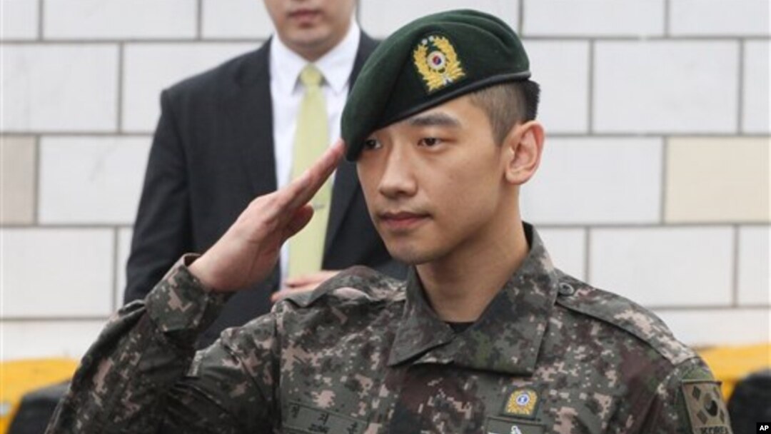 Aktor dan penyanyi Korea Selatan Rain memberi hormat pada penggemar dan media di depan kantor Kementerian Pertahanan di Seoul (10/7), setelah menjalani wajib militer selama 21 bulan. (AP/Ahn Young-joon)