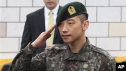 Aktor dan penyanyi Korea Selatan Rain memberi hormat pada penggemar dan media di depan kantor Kementerian Pertahanan di Seoul (10/7), setelah menjalani wajib militer selama 21 bulan. (AP/Ahn Young-joon)