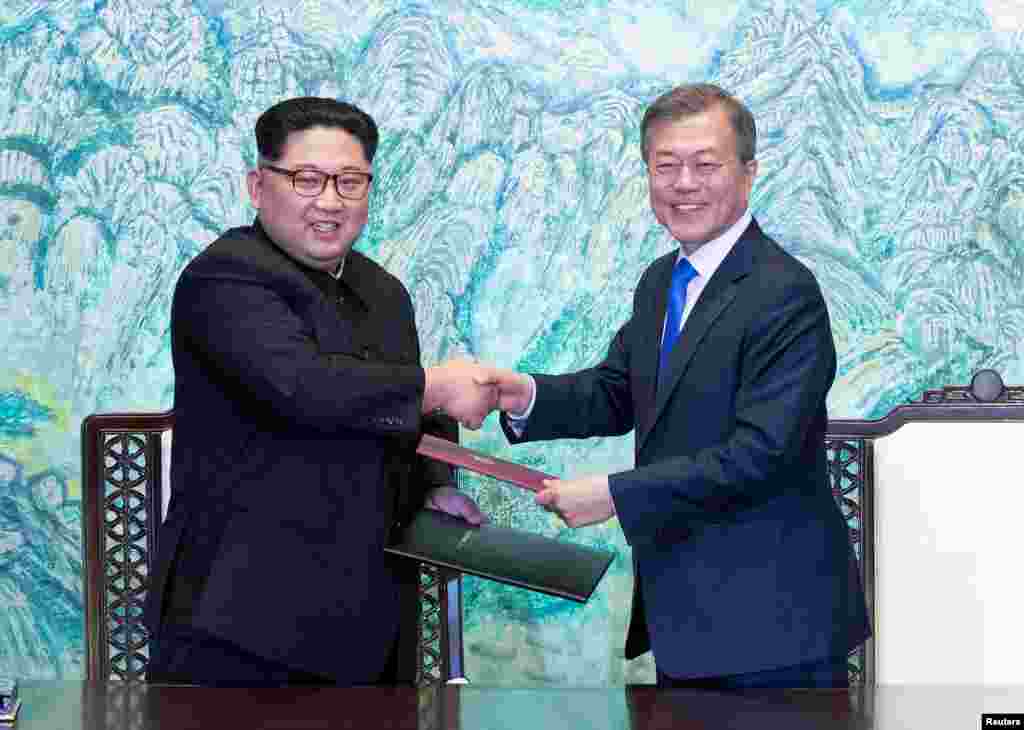 South Korean President Moon Jae-in and North Korean leader Kim Jong Un shake hands at the truce village of Panmunjom inside the demilitarized zone separating the two Koreas, South Korea, April 27, 2018.
