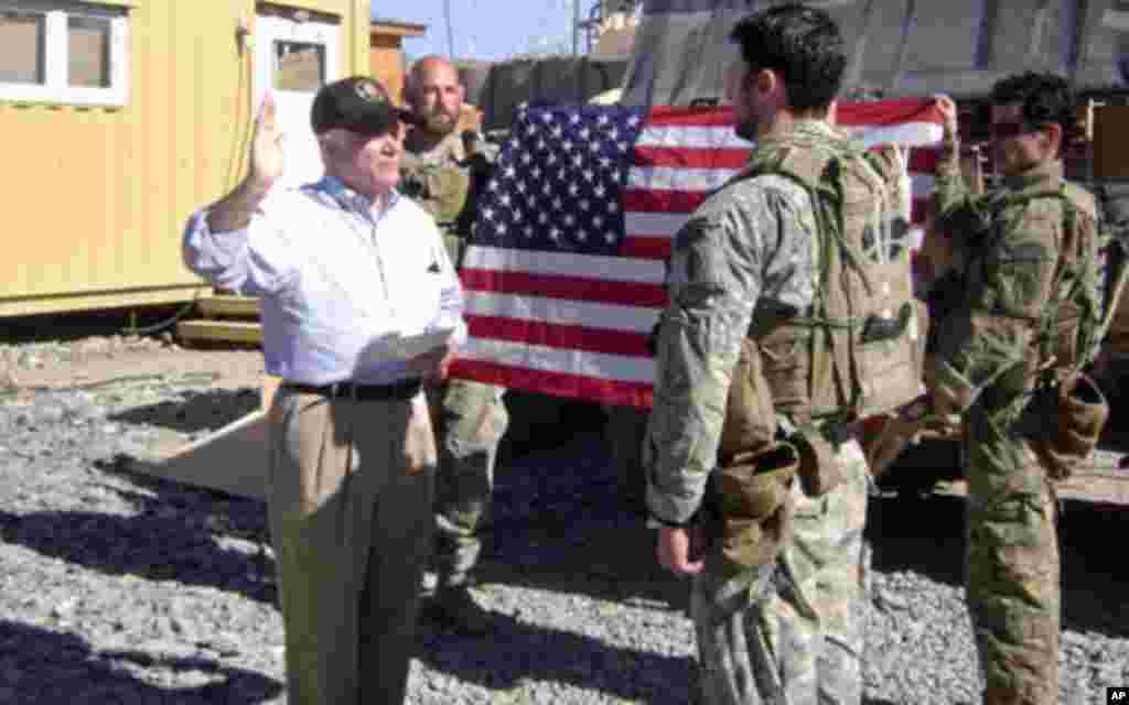 Secretary Gates administers a reenlistment oath to a U.S. soldier during his visit to Combat Outpost Kowall near Tabin village