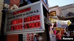 People check currency exchange rates at a currency exchange office in Istanbul, Turkey, Aug. 10, 2018.