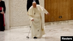 Pope Francis stumbles when part of his walking cane breaks as he arrives to hold the Jubilee audience in Paul VI hall at the Vatican, Feb. 1, 2025. 