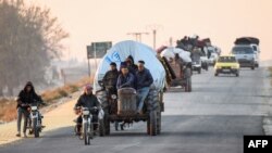 Displaced Syrian Kurds drive their vehicles loaded with belongings on the Aleppo-Raqqa highway as they flee areas on the outskirts of the northern city of Aleppo which were formerly controlled by the Kurdish-led Syrian Democratic Forces (SDF), after they 