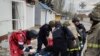 Спасатели несут тело мужчины, погибшего во время российского обстрела в Белозерке под Херсоном 16 ноября 2023 г. (Фото предоставлено Украинской службой спасения)