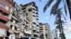 Cars go past a damaged building in Tyre, Lebanon, Jan. 24, 2025. 