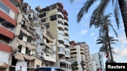 Cars go past a damaged building in Tyre, Lebanon, Jan. 24, 2025. 