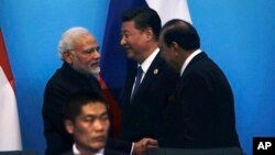 PM India Narendra Modi (kiri) berjabat tangan dengan Presiden Pakistan Mamnoon Hussain (kanan) di dekat Presiden China Xi Jinping usai konferensi pers bersama SCO, di Qingdao, China, Minggu (10/6). 