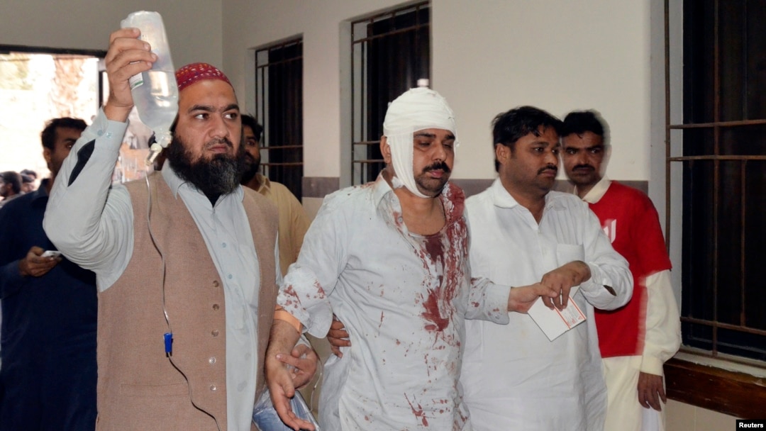 FILE - A man injured in an explosion in a Shi'ite mosque walks with relatives after receiving medical treatment at a hospital in Shikarpur, located in Pakistan's Sindh province, Jan. 30, 2015. 