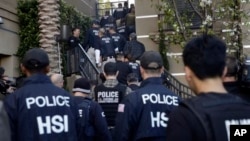 Federal agents enter an upscale apartment complex where authorities say a birth-tourism business charged pregnant women $50,000 for lodging, food and transportation, Irvine, Calif., March 3, 2015.