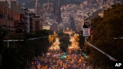 Con la iglesia de la Sagrada Familia de fondo, decenas de miles de manifestantes marchan durante una llamada de protesta por la liberación de los políticos catalanes encarcelados. Barcelona, España, 11 de noviembre de 2017.