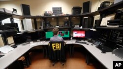 Seorang pegawai Biro Penyelidikan Federal AS (FBI) bekerja di komputer lab forensik di kantor FBI di New Orleans, 31 Juli 20218. 