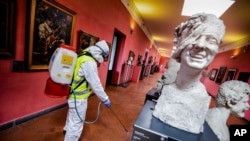 A worker sprays disinfectant as sanitization operations against Coronavirus are carried out in the museum hosted by the Maschio Angioino medieval castle, in Naples, Italy, March 10, 2020. 