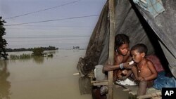 Wata 'ya mace take ciyar da kaninta abinci a wani muhalli da aka tsara sakamakon ambaliyar ruwa a India.