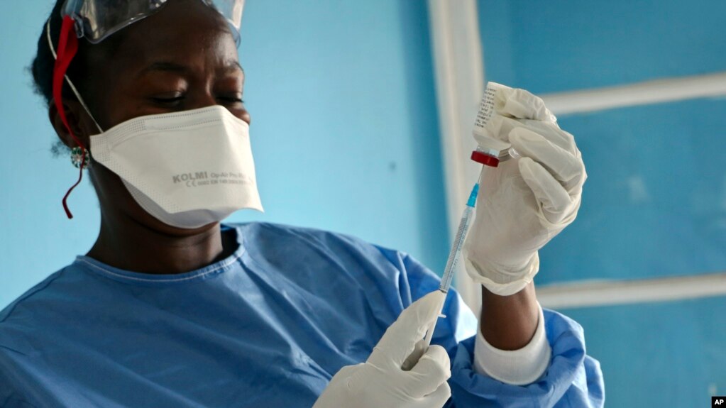 FILE - In this Wednesday, May 30, 2018 file photo, a healthcare worker from the World Health Organization prepares Ebola vaccines to give to frontline aid workers, in Mbandaka, Congo. 