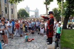 A Yeoman Warder, Barney Chandler gestures as he leads the first 'Beefeater' tour of the Tower of London in 16 months, at the Tower of London, July 19, 2021.