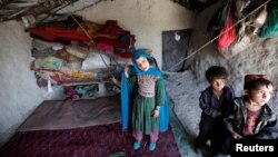 Afghan children stand inside a shelter at a refugee camp in Kabul May 31, 2016. Amnesty International says the number of internally displaced people in Afghanistan has doubled to 1.2 million since 2013.