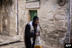 An ultra-Orthodox Jewish man walks past a mosque at the start of the Jewish holiday of Yom Kippur in Jerusalem on Oct. 11, 2024.