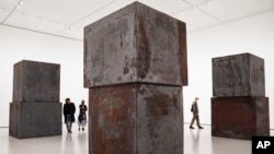 Visitantes exploran "Equal" de Richard Serra en el Museo de Arte Moderno en Nueva York en nuevo espacios de exhibición abierto noviembre de 2020, Serra creaba obras en acero oxidado y otros materiales maleables en obras de arte al aire libre a gran escala.
