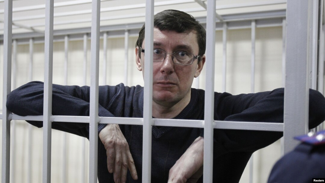 Mantan Mendagri Ukraina Yuriy Lutsenko menatap keluar dari dalam selnya saat berlangsung persidangannya di Kiev, Februari lalu.