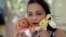 Inga Whatcott, adopted from Russia, holds two stuffed dolls she saved from her orphanage in Russia, outside her apartment in Battle Creek, Michigan, May 2013.